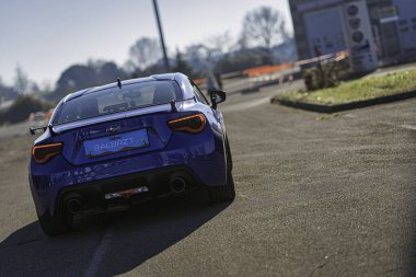 Imola, İtalya 01 Ocak 2026: özel spoiler ve çift egzozlu mavi subaru brz spor coupe coupe back view, güneş ışığında hızla sürükleniyor.