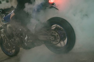 Imola, İtalya 01 Ocak 2026: motorsikletli bir sporcu muhteşem bir patinaj dublörü, dönen arka lastikten büyük bir beyaz duman bulutu üretiyor