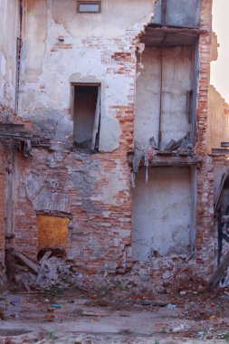 Bu görüntü, harap olmuş bir binada çürümenin ve terk edilmenin ham özünü yakalar. Parçalanmış tuğla duvarlar, açıkta kalmış iç kısımlar ve dağınık enkazlar ihmalkarlık ve zamanın geçişi hakkında bir hikaye anlatıyor.
