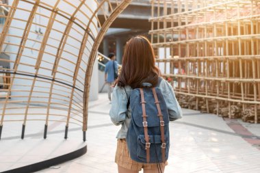 Genç ve çekici Asyalı kadın turistin şehir dışında dikilirken görüntüsü