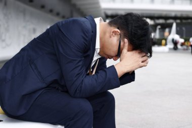 İşsiz ve stresli Asyalı iş adamı ağır depresyondan muzdarip. Başarısızlık ve işten çıkarma kavramı.