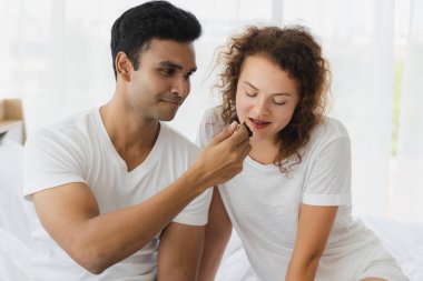 Romantik genç çift yatak odasında birlikte pastanın tadını çıkarıyor..