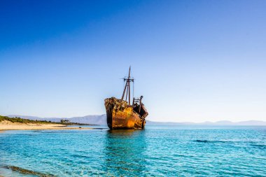 Yunanistan 'ın başkenti Mora' da Gythio yakınlarındaki bir sahil şeridinde paslı ve terk edilmiş bir gemi enkazı.