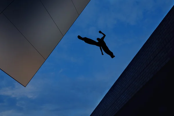 Man jumping over building roof against blue sky background — Stock Photo, Image