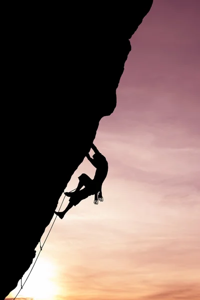 Silueta de escalador en la cara de roca imagen vertical — Foto de Stock