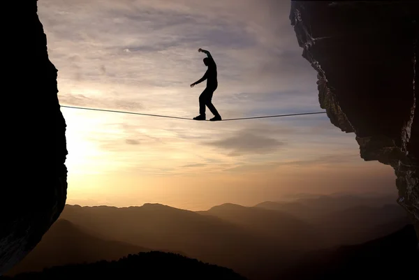 Homem equilibrando o conceito de corda de correr riscos — Fotografia de Stock