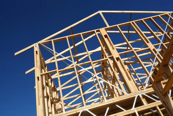 Nova construção casa enquadramento contra o céu azul — Fotografia de Stock