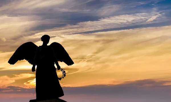 Sculptură înger pe fundal apus de soare — Fotografie, imagine de stoc