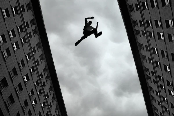 Homem pulando de telhado em telhado — Fotografia de Stock