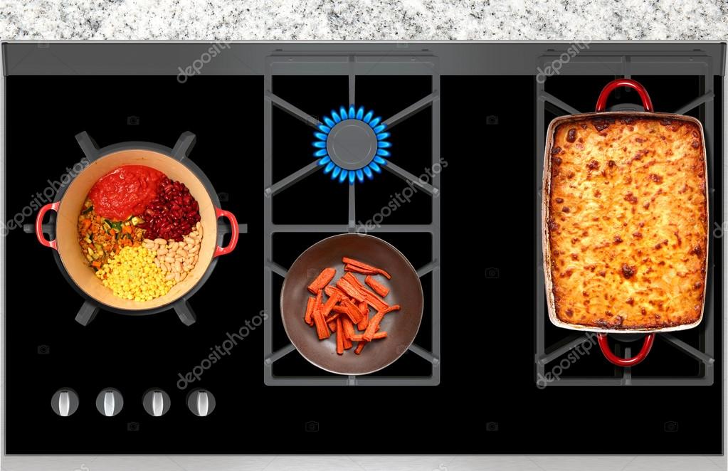 Cooking on a gas stove casserole and vegetables top view Stock Photo by
