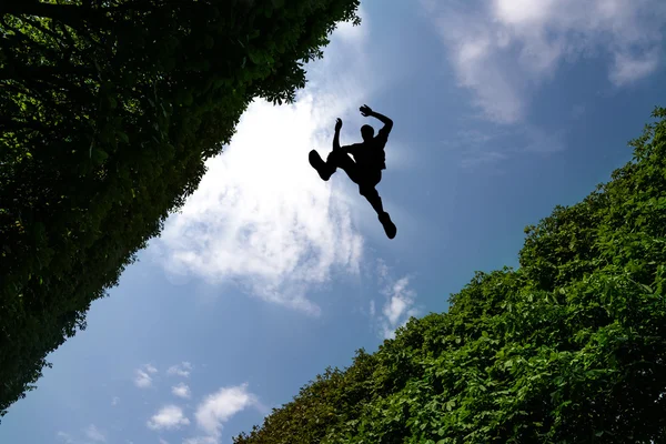 Man jumping over bushes — Stock Photo, Image