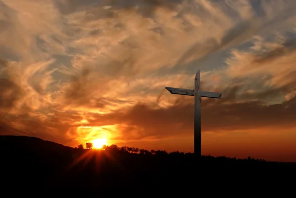 Christliches Kreuz über dem Hintergrund des Sonnenuntergangs — Stockfoto
