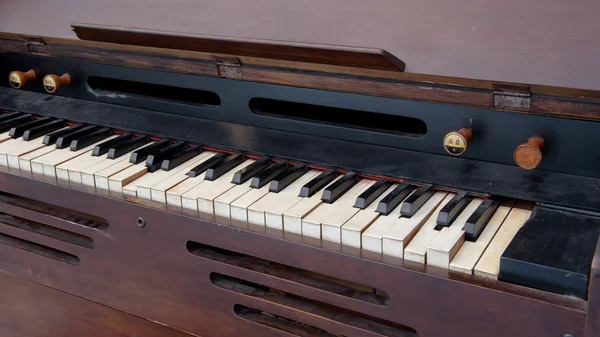 Vecchio pianoforte in legno nella stanza bianca — Foto Stock