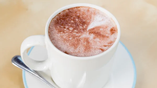 Heiße Schokolade in einer weißen Tasse auf dem Tisch — Stockfoto