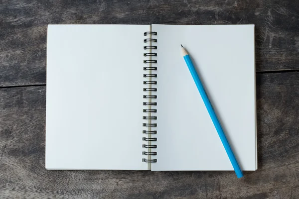 Натюрморт с белой тетрадкой и карандашом на столе — стоковое фото