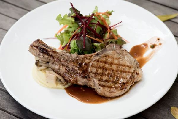 Bife t-bone com legumes em fundo de madeira escura — Fotografia de Stock