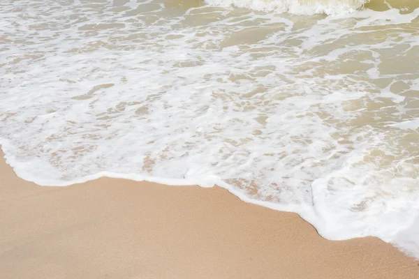 Zelené oceánu vlnu s bílým pískem na pozadí — Stock fotografie