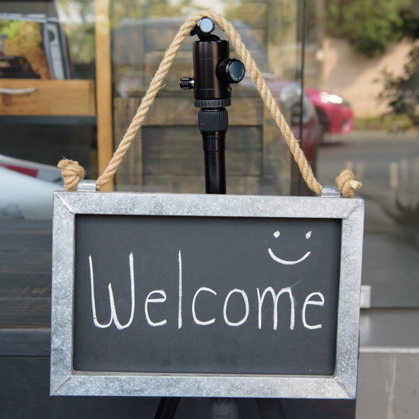 Деревянная винтажная рама ДОБРО ДОМА над старой голубой деревянной спинкой
