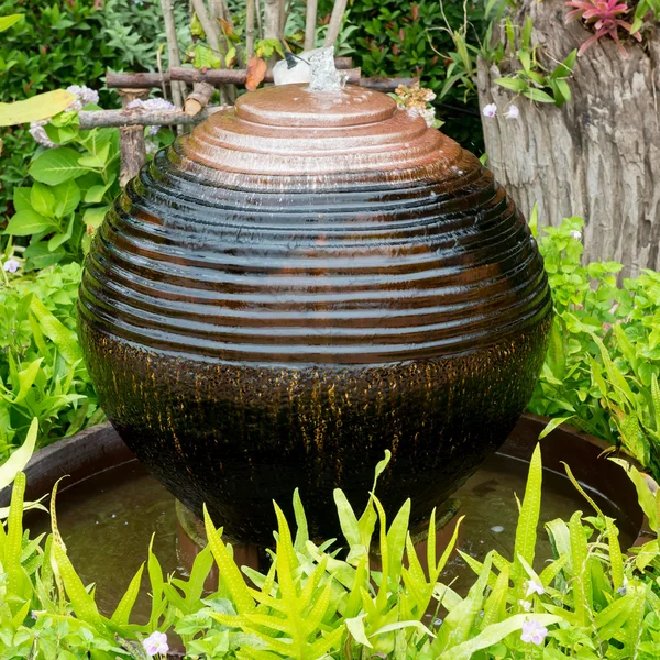 Tarro de cerámica con agua en jardín verde — Foto de Stock