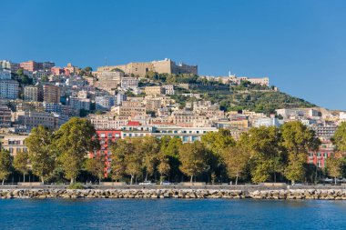 Seafront and buildings on the hills of Naples with Sant'Elmo Castle in the background, Italy