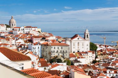 Portekiz 'in Lizbon kentindeki tarihi Alfama bölgesinin manzarası, Tagus Nehri' ne doğru kırmızı kiremitli ve Miradouro de Santa Luzia 'nın uzak güney yasağı olan yoğun bir bina kümesine bakıyor.