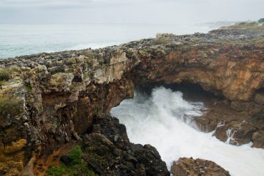 Portekiz 'in Cascais kenti yakınlarındaki sahil kayalıklarında bulunan Boca do Inferno (Cehennem Ağzı) adlı dramatik doğal kaya oluşumunun görüntüsü..