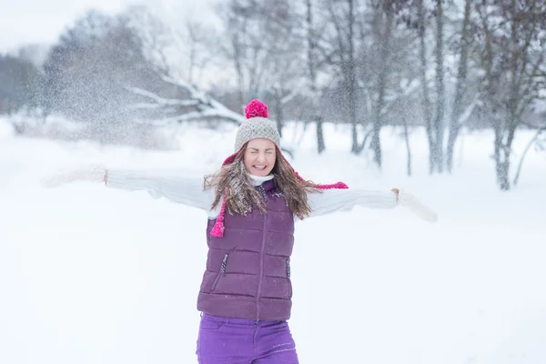 Красавица, играющая со снегом на улице — стоковое фото