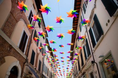 Pietrasanta Toskana İtalya 'nın ana caddesini yaz günlerinde dekore etmek için çok renkli fırıldak. 