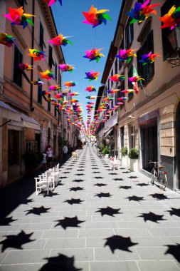 Pietrasanta Toskana İtalya 'nın ana caddesini yaz günlerinde dekore etmek için çok renkli fırıldak. 