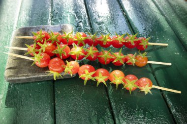 Pachino, Sicilya İtalya 'dan gelen vişneli domateslerle yapılan üç şişin foto sunumu, sulu ve lezzetli kırmızılar 