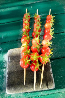 Pachino, Sicilya İtalya 'dan gelen vişneli domateslerle yapılan üç şişin foto sunumu, sulu ve lezzetli kırmızılar 