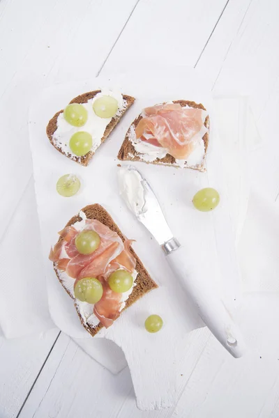 Bread, cheese and ham and grapes — Stock Photo, Image