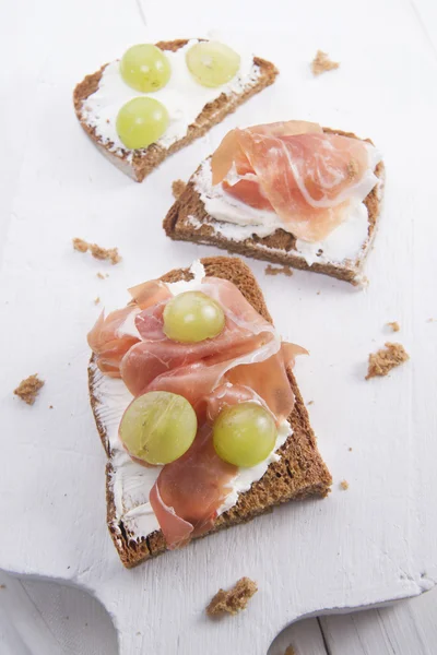 Bread, cheese and ham and grapes — Stock Photo, Image