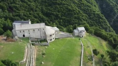 İtalya 'nın Lecco ilindeki San Pietro al Monte Manastırı' nın etrafında uçuşan, doğayla çevrili ortaçağ dini kompleksinin havadan görünüşü