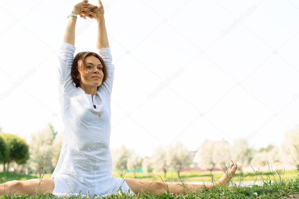 Young attractive woman practicing yoga outdoors. 