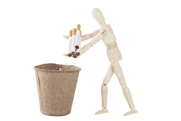 Дерев'яний маннекін кидає в смітник деякі сигарети — стокове фото