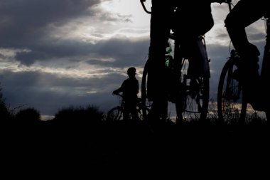 Batan güneşin ışığında bir bisikletçinin silueti.