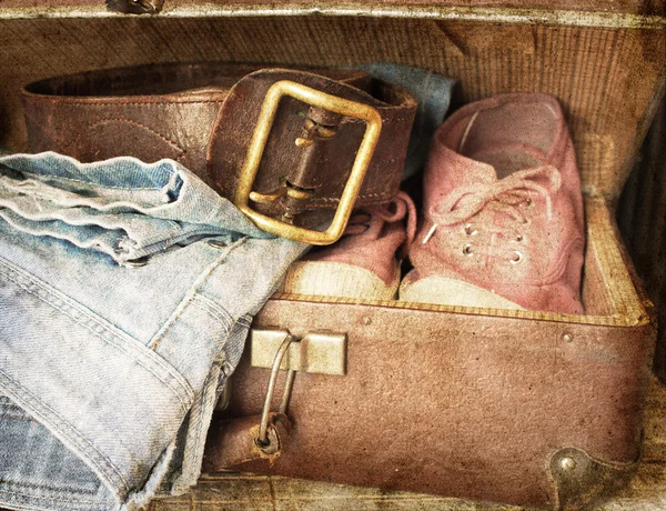 Para dżinsy, buty, pas w rocznika walizki — Zdjęcie stockowe