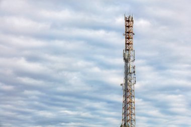 Yüksek telekomünikasyon kulesi 3G, 4G ve 5G hücresel iletişim antenleri mavi bulutlu gökyüzüne karşı, boşluğu kopyala.