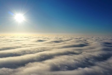 Aerial photography, rays of bright sunlight falling on wavy gray clouds. A photograph about 500 meters high, taken from a height by a latest generation drone.