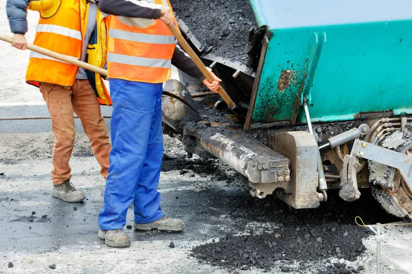 工人们用铲子清扫新路段前的沥青路面 有选择的重点 — 图库照片