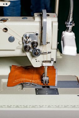 Modern bir dikiş makinesinin, deri döşeme ve çeşitli yoğun kumaşlar dikmek için kullandığı dikiş makinesinin çalışma kısmı. Dikey resim, boşluğu kopyala.