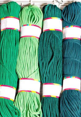 Çeşitli yeşil tonlarda polyester kablo ruloları yuvarlandı. Dikey resim, boşluğu kopyala.