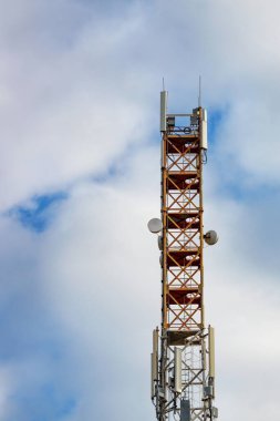 Telekomünikasyon kulesi uydu ve hücresel iletişim 3G, 4G ve 5G antenleri ile mavi bulutlu gökyüzünün arka planında. Dikey resim, boşluğu kopyala.