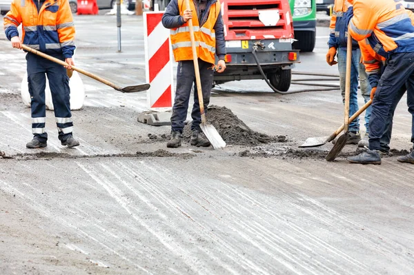 Vejarbejdere Orange Overalls Renser Vejen Med Skovle Indhegnet Område Kørebanen - Stock-foto