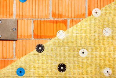 Modern binalardaki ısı kaybını azaltma konsepti, mineral yünlü bir binanın tuğla duvarının yalıtımı.