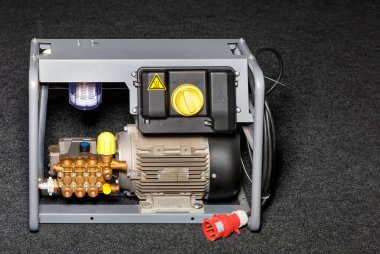 Araba yıkama, açık hava temizliği, atölye temizliği, havuz temizliği için güçlü bir endüstriyel yüksek basınçlı çamaşır makinesi. Gri arkaplandaki resim, boşluğu kopyala.