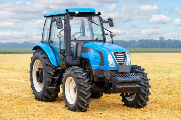 Колесный Современный Синий Трактор Стоит Фоне Собранного Желтого Пшеничного Поля — стоковое фото