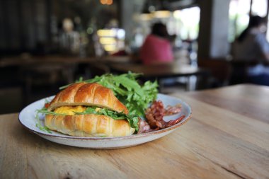 yumurta ve pastırma tahta arka plan ile kruvasan