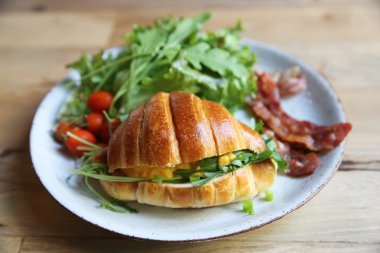 yumurta ve pastırma tahta arka plan ile kruvasan